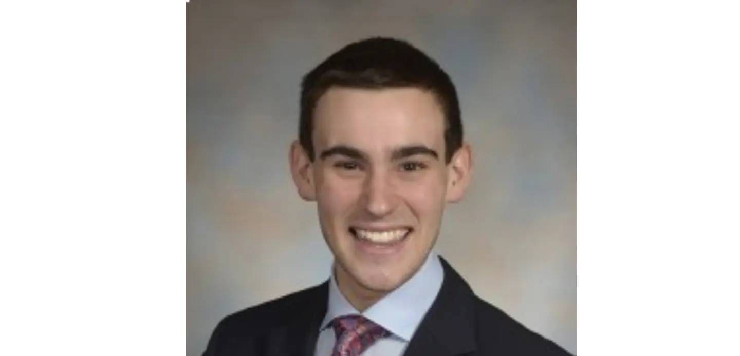 A young man in suit and tie smiling for the camera.