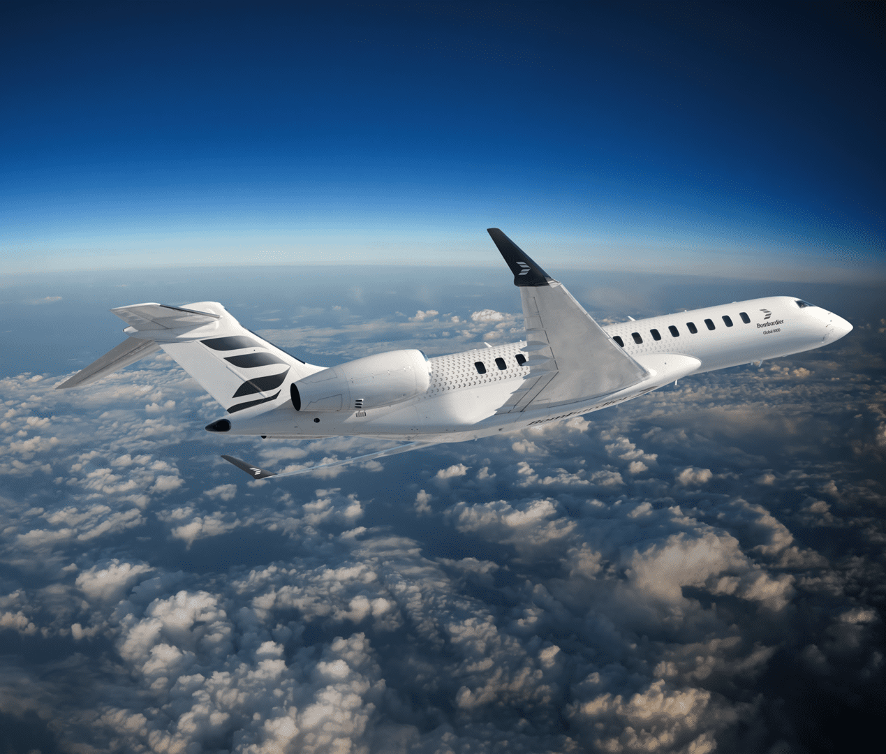 A white airplane flying over the clouds in the sky.