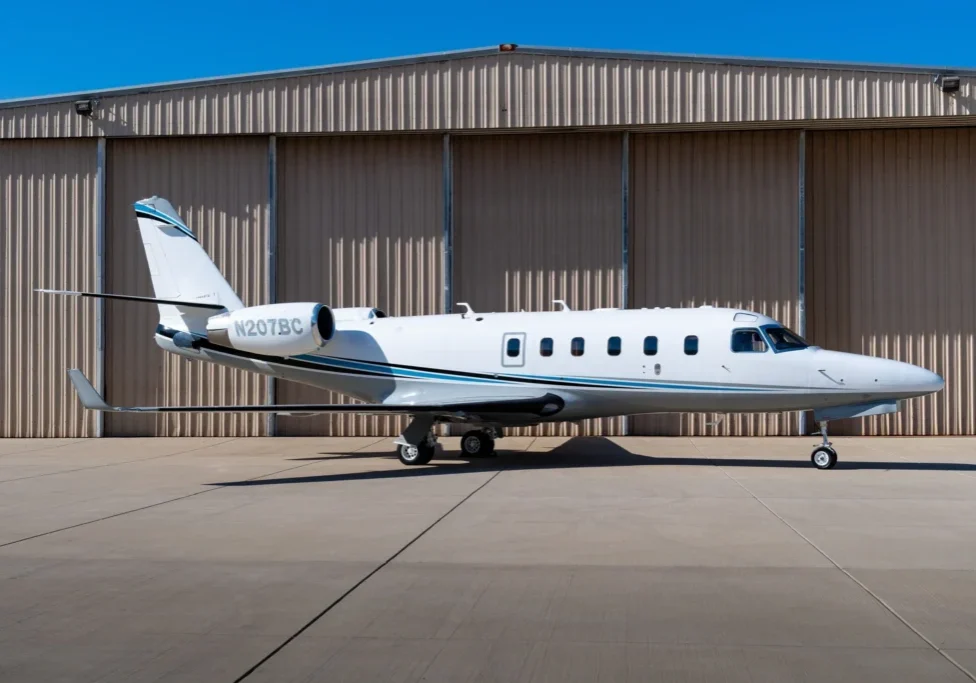 Private jet parked outside a hangar.