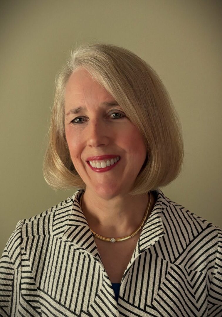 A woman with blonde hair wearing a striped shirt.