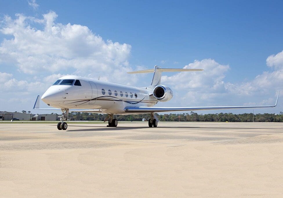 A white jet airplane sitting on top of an airport runway.