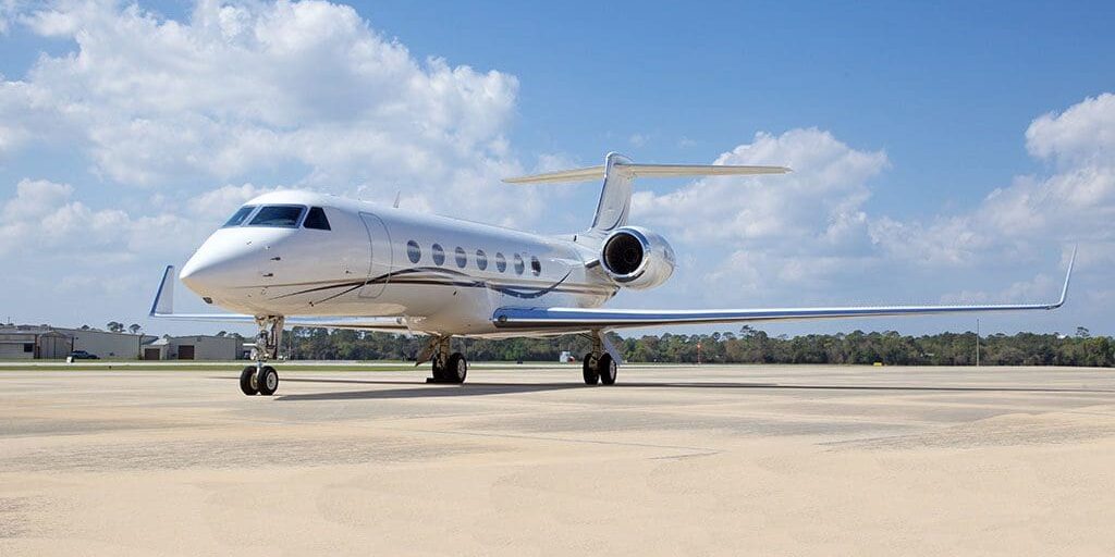 A white jet airplane sitting on top of an airport runway.