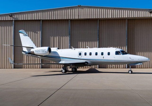 A small white plane parked on the tarmac.