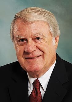 A man in suit and tie smiling for the camera.